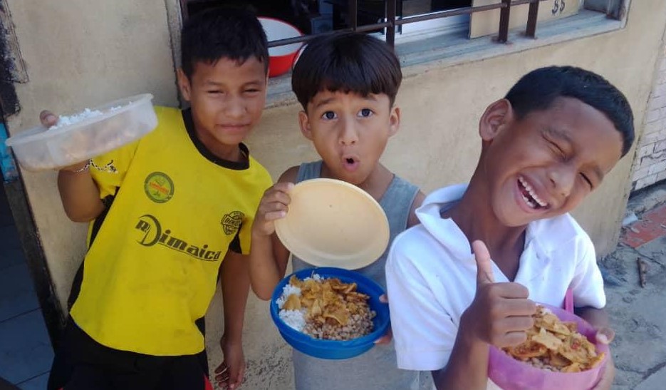 Smiling-Children-In-Venezuela-Holding-Plates-of-Food-With-Thumbs-Up